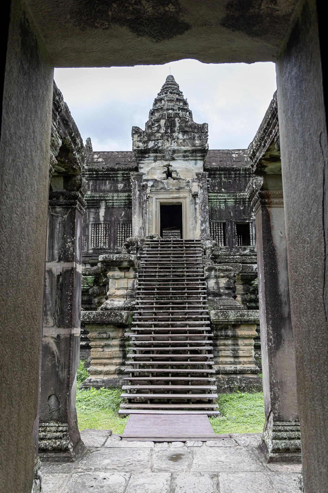 A temple tower and staircase framed by a dark stone doorway.