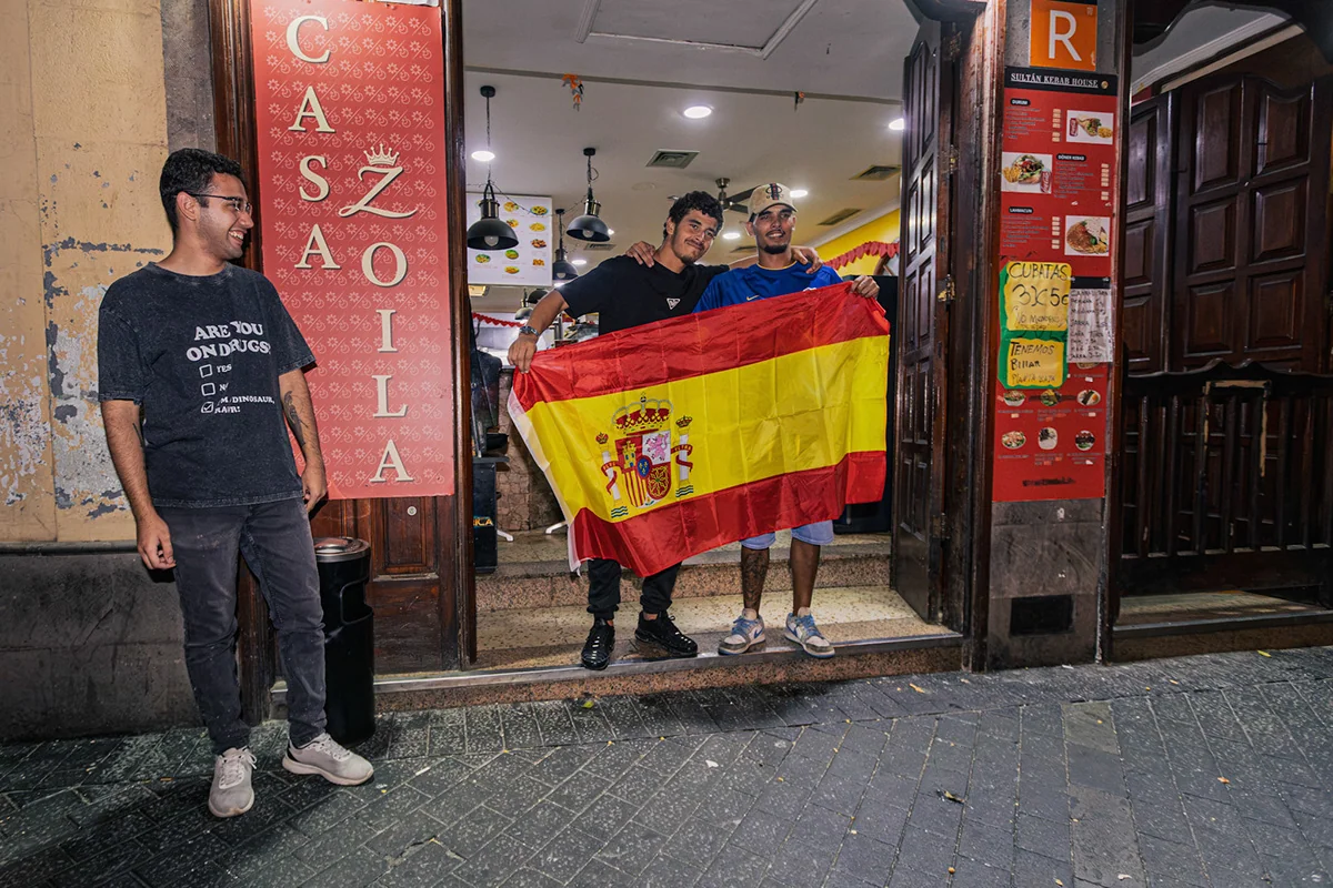 Supporters holding a Spanish flag at the entrance to a restaurant.