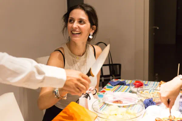 A guest laughing as cake is served at a celebration.