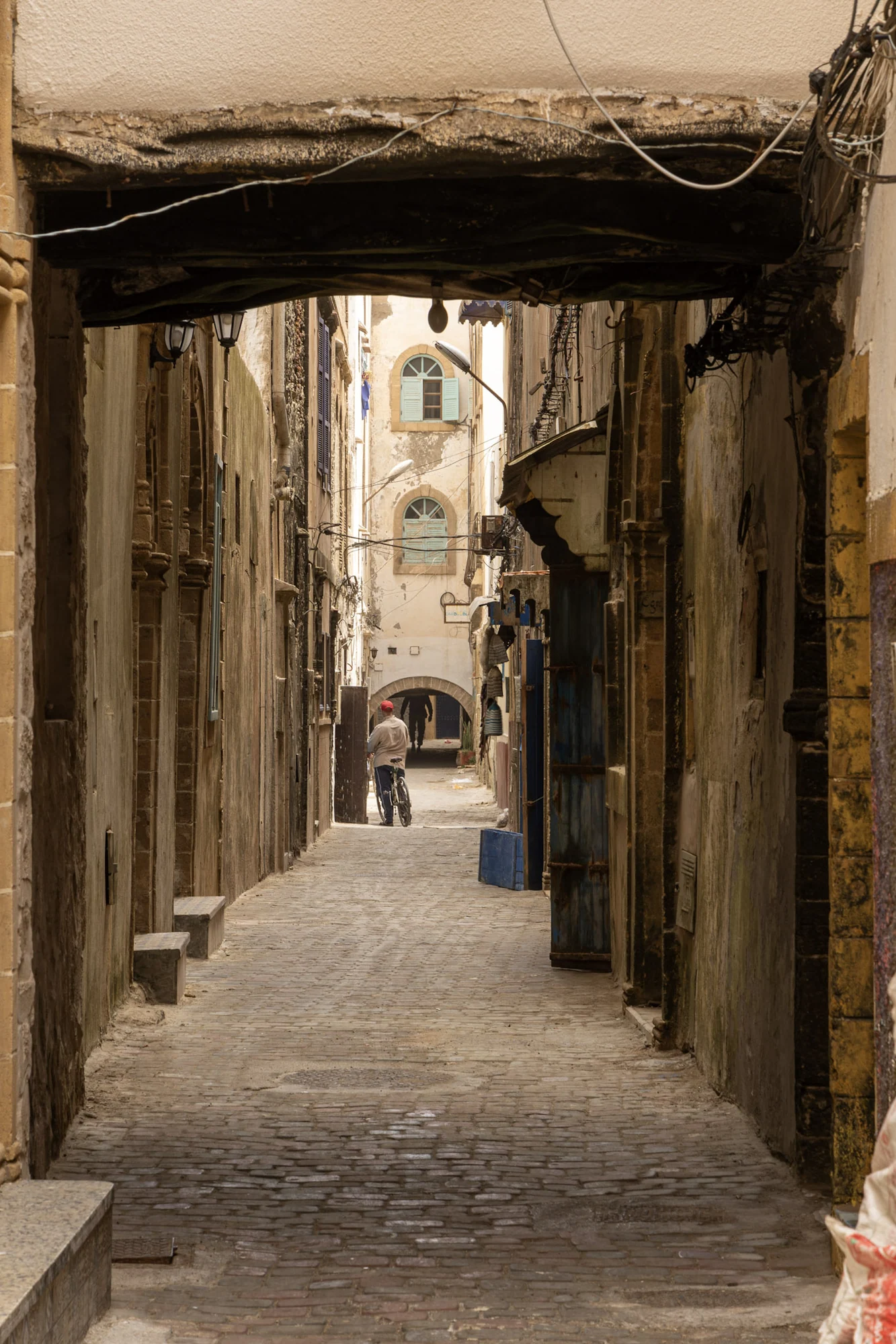 A narrow stone alley leading through covered doorways.