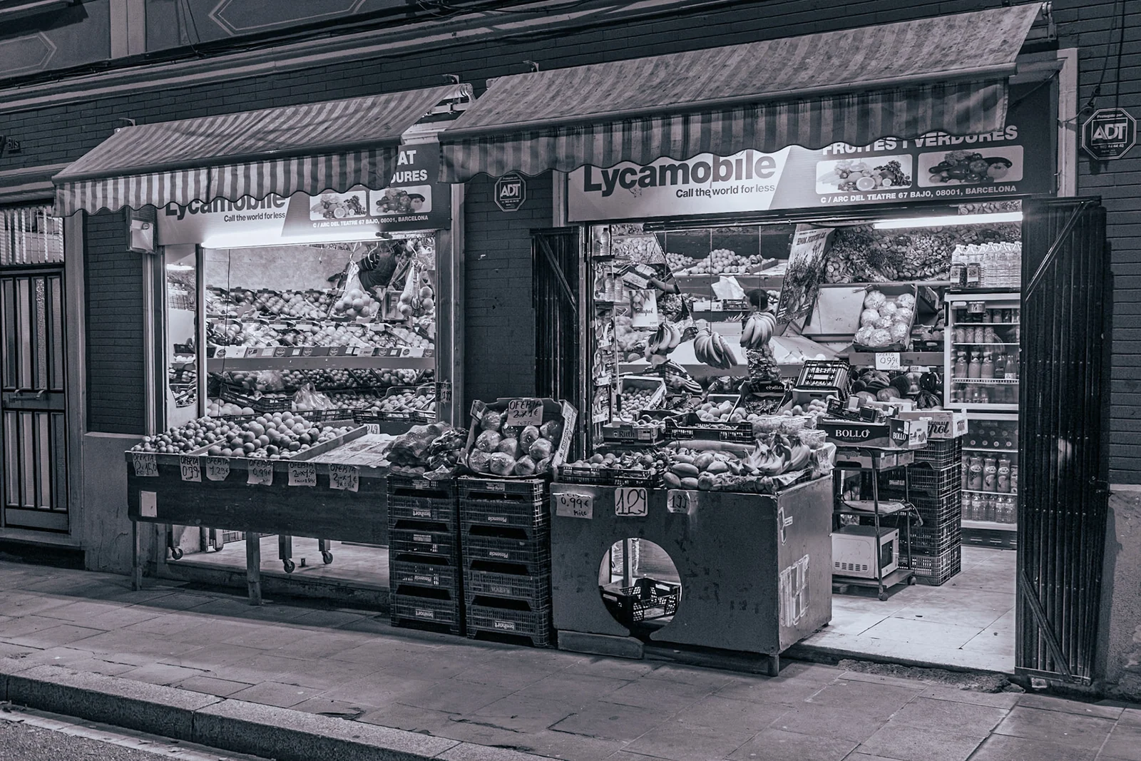 A small street kiosk in a black and white photograph.