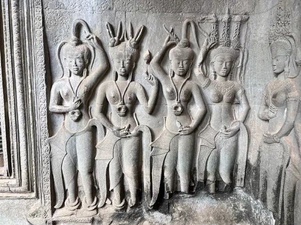 A group of figures carved in relief on a temple wall.